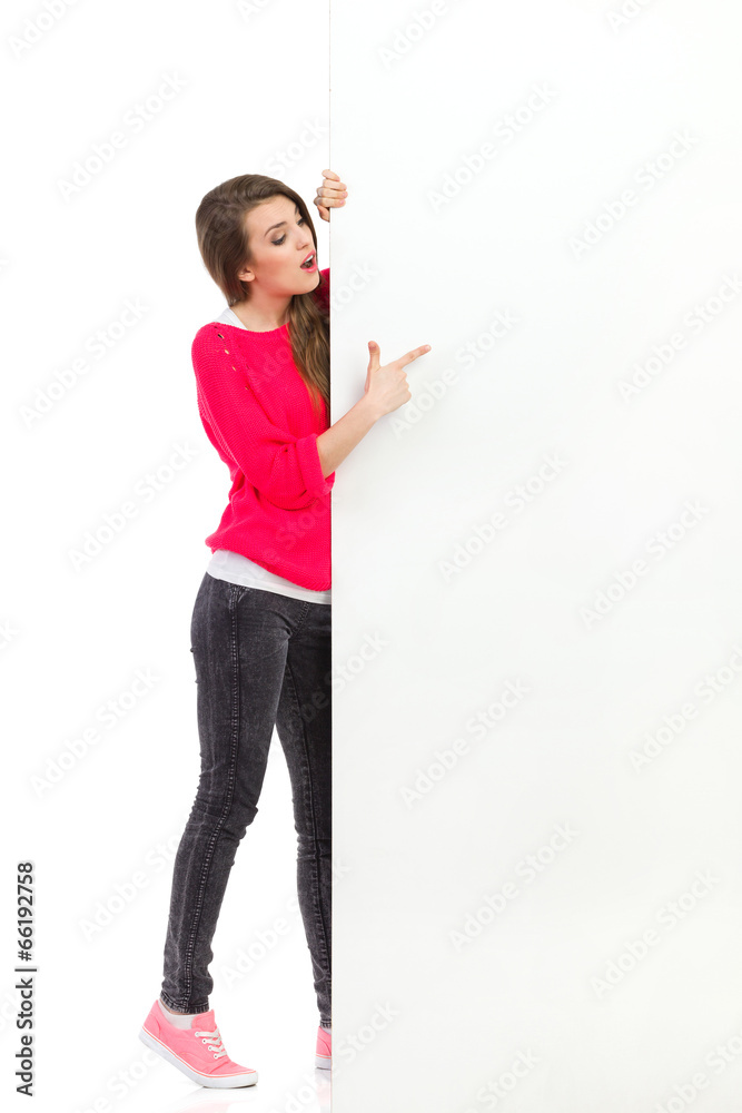Surprised woman pointing at big white placard Surprised woman pointing at big white placard