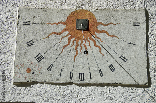 Ancient sundial with signs of the zodiac on white  wall