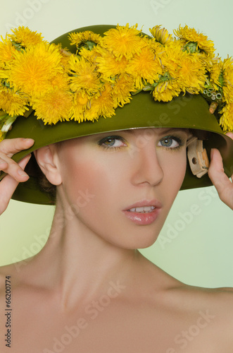 Young woman in helmet with a wreath of dandelions
