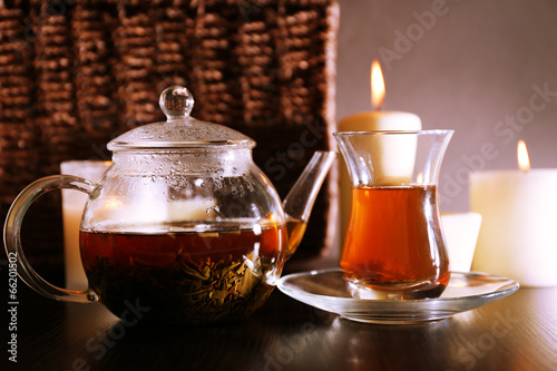 Composition with tea in glass teapot and candles