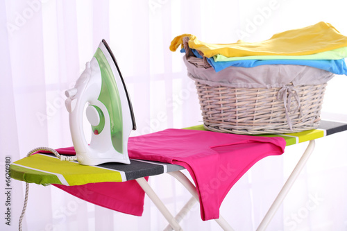 Basket with laundry and ironing board photo