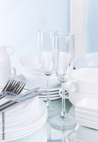 Set of white dishes on table on light background