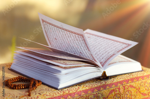 Open Quran  (holy book of Islam ) for pray on the table in the sunlight 