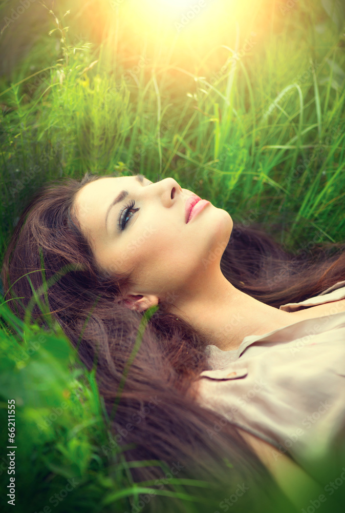Beauty woman lying on the field and dreaming. Enjoying nature Beauty woman lying on the field and dreaming. Enjoying nature