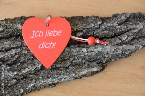 Ich liebe dich - Aufschrift auf rotem Herz aus Holz photo