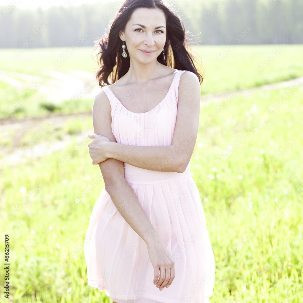 Beautiful woman in pink dress standing outdoors Beautiful woman in pink dress standing outdoors