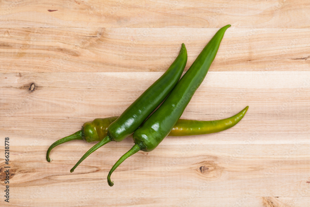 Green chili peppers on wooden table Green chili peppers on wooden table