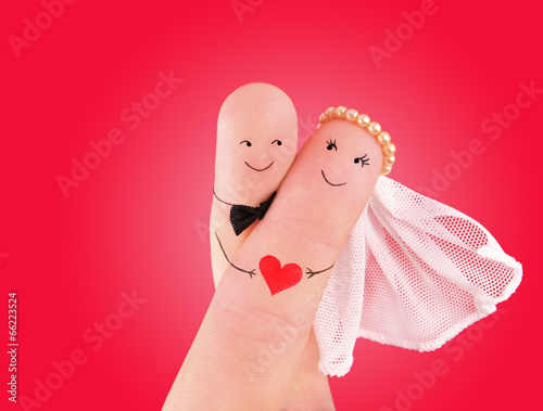 just married couple - newlyweds painted at fingers against red b