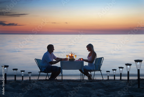 A young couple share a romantic dinner with candles