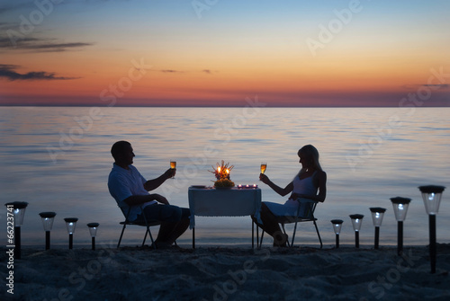 A young couple share a romantic dinner with candles and wine