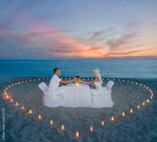 couple at beach romantic dinner with candles heart