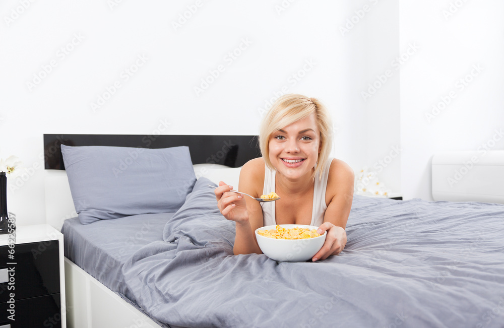 Breakfast in bed, young woman lying on bed Breakfast in bed, young woman lying on bed
