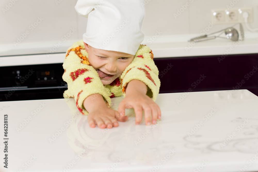 Silly boy wearing toque playing with flour Silly boy wearing toque playing with flour