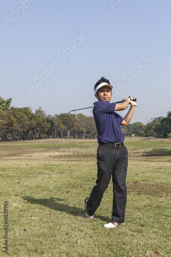 Male golfer player teeing off golf ball from tee box