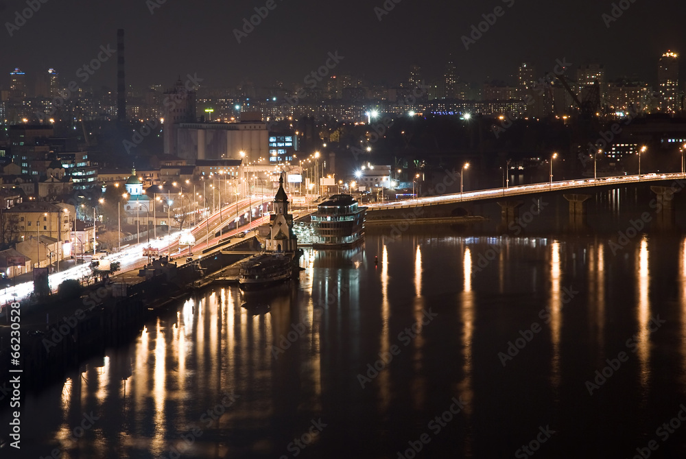 Night city view with the river, road, buildings and lights. Kyiv