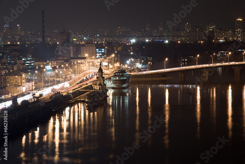 Night city view with the river, road, buildings and lights. Kyiv