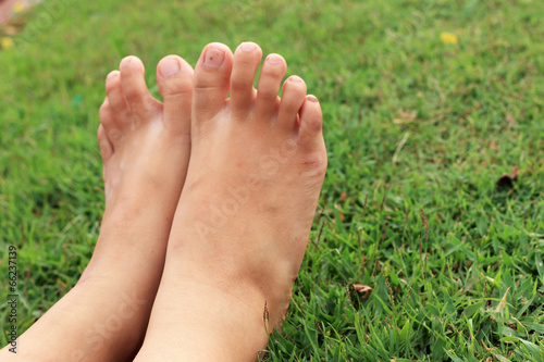 Barefoot on a green lawn.