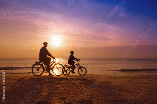 father and son at the beach on sunset,Biker family silhouette