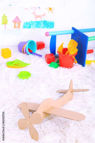 Paper airplane toy in room on the carpet