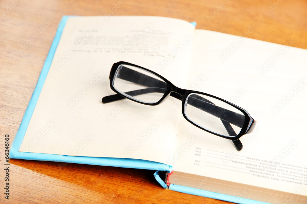 Composition with old book, eye glasses,  on wooden background