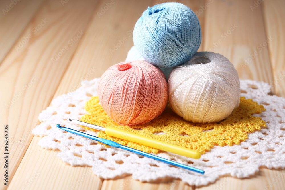 Colorful clews, napkin and crochet hook on wooden background Colorful clews, napkin and crochet hook on wooden background