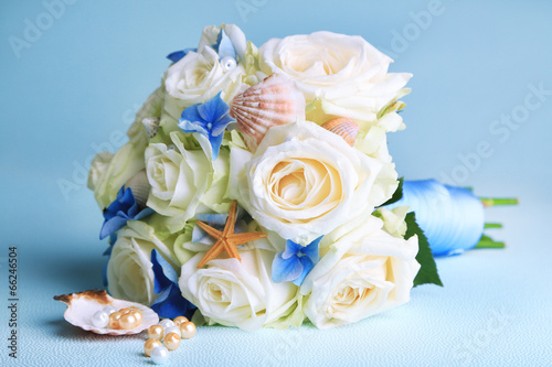 Beautiful wedding bouquet with roses on blue background