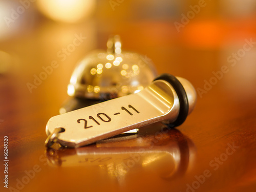 Hotel bell and key lying on the counter at the hotel reception in the lobby photo