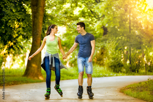 Smiling couple riding rollerblades photo