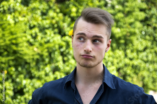 Attractive young man with unsure expression, thinking