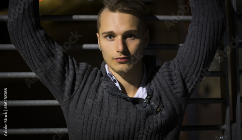 Handsome blond young man alone in urban setting