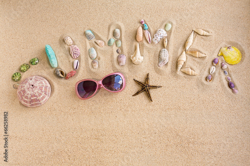 Word summer made from sea shells, with sunglasses and star fish,