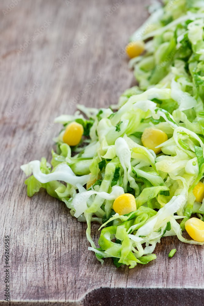 Cabbage salad with corn on wooden board