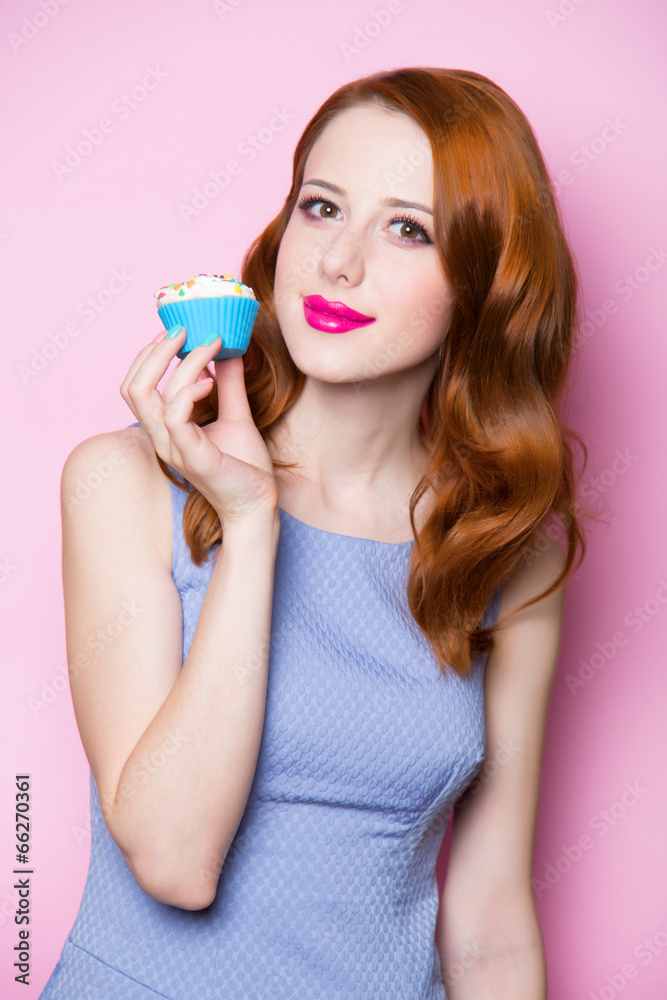 Redhead girl with cupcake in pink background. Redhead girl with cupcake in pink background.