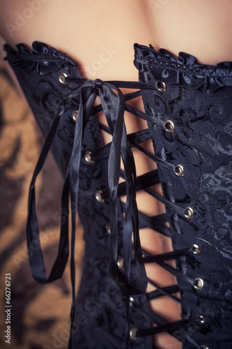 Fotografia woman wearing black corset and pearls against retro background