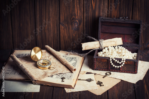treasure chest, compass and old map on wooden table