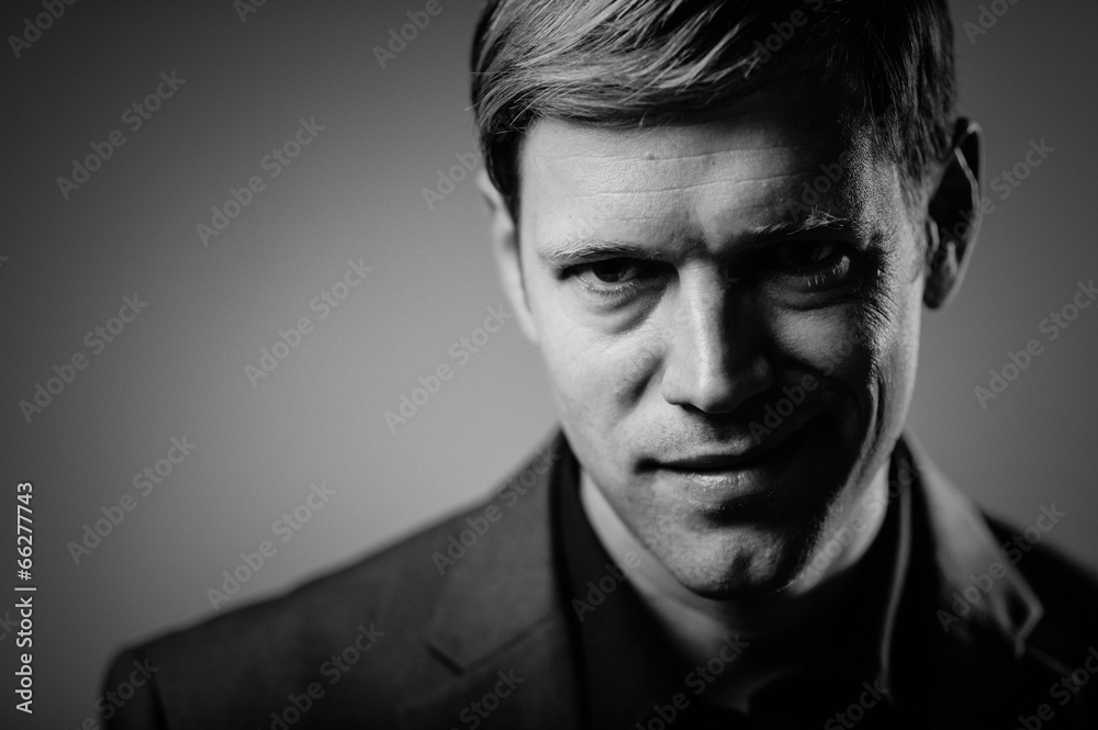 Handsome man portrait with an evil smirk Handsome man portrait with an evil smirk
