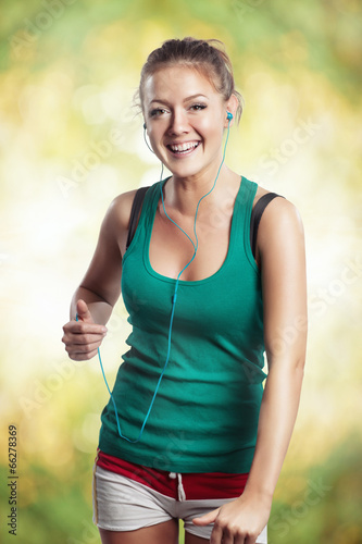 Young woman running outdoors with music player