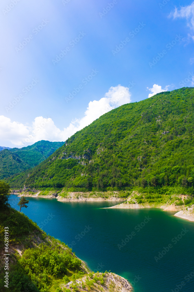 Mountain lake. Beautiful landscape with lake, forest and mounta Mountain lake. Beautiful landscape with lake, forest and mounta