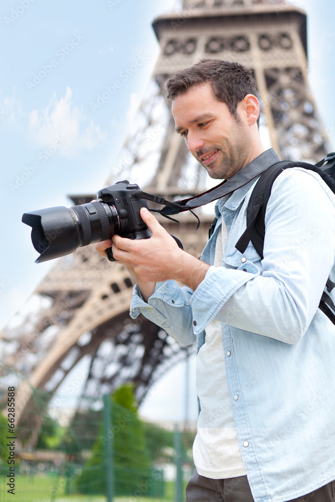 Young attractive tourist taking pictures in Paris