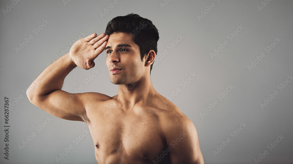Fototapeta premium Young muscular man saluting
