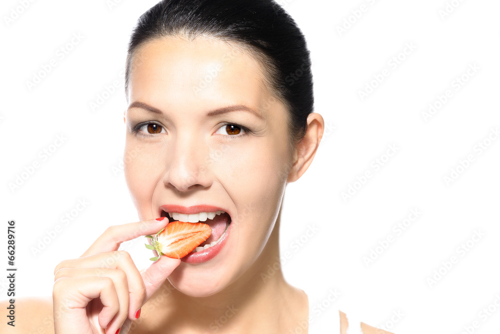 Junge Frau isst eine reife Erdbeere