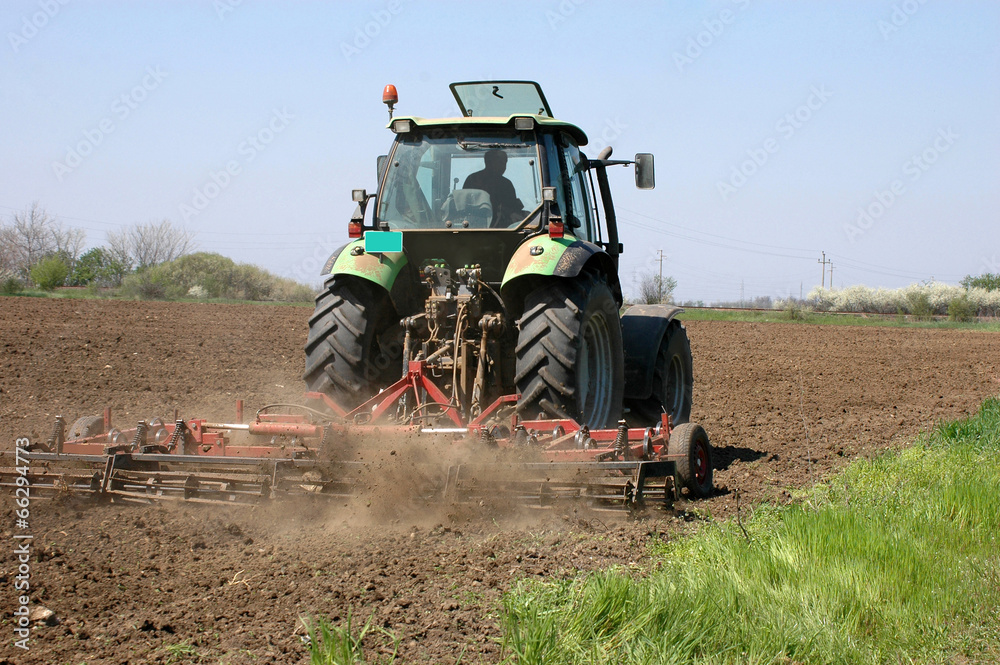 Obraz premium Farming a field with a tractor