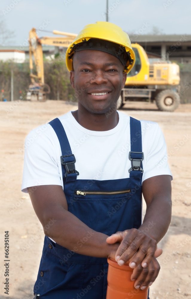 Standing african construction worker with pipe Standing african construction worker with pipe