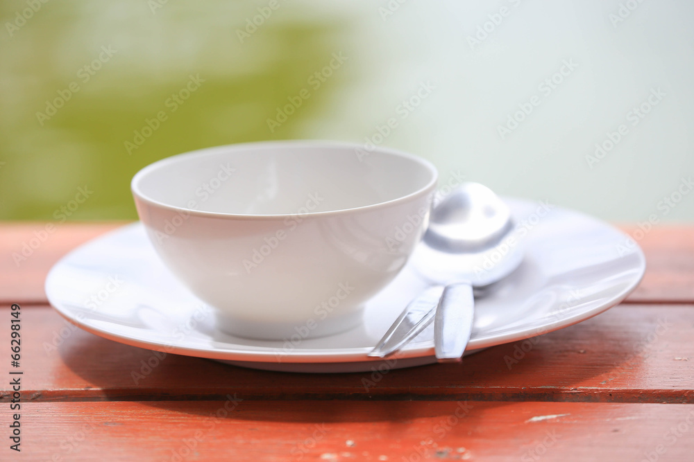 plate with spoon on wooden table plate with spoon on wooden table
