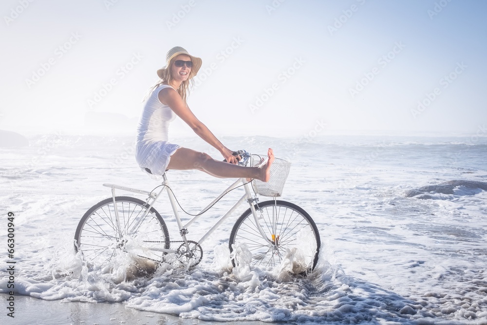 Fototapeta premium Gorgeous happy blonde on a bike ride at the beach