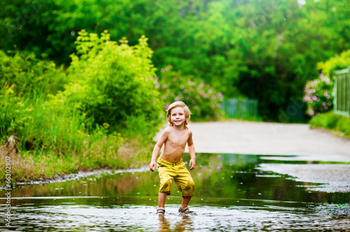 Fototapeta Naklejka Na Ścianę i Meble -  Splashing in a puddle