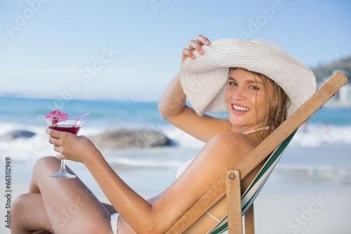 Smiling woman relaxing in deck chair with cocktail © WavebreakmediaMicro