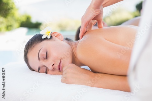 Attractive couple enjoying couples massage poolside