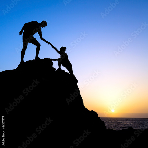 Man and woman help silhouette in mountains