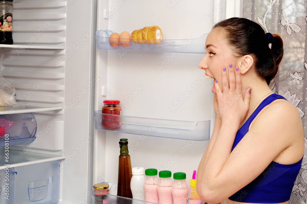 Girl in horror at the open refrigerator